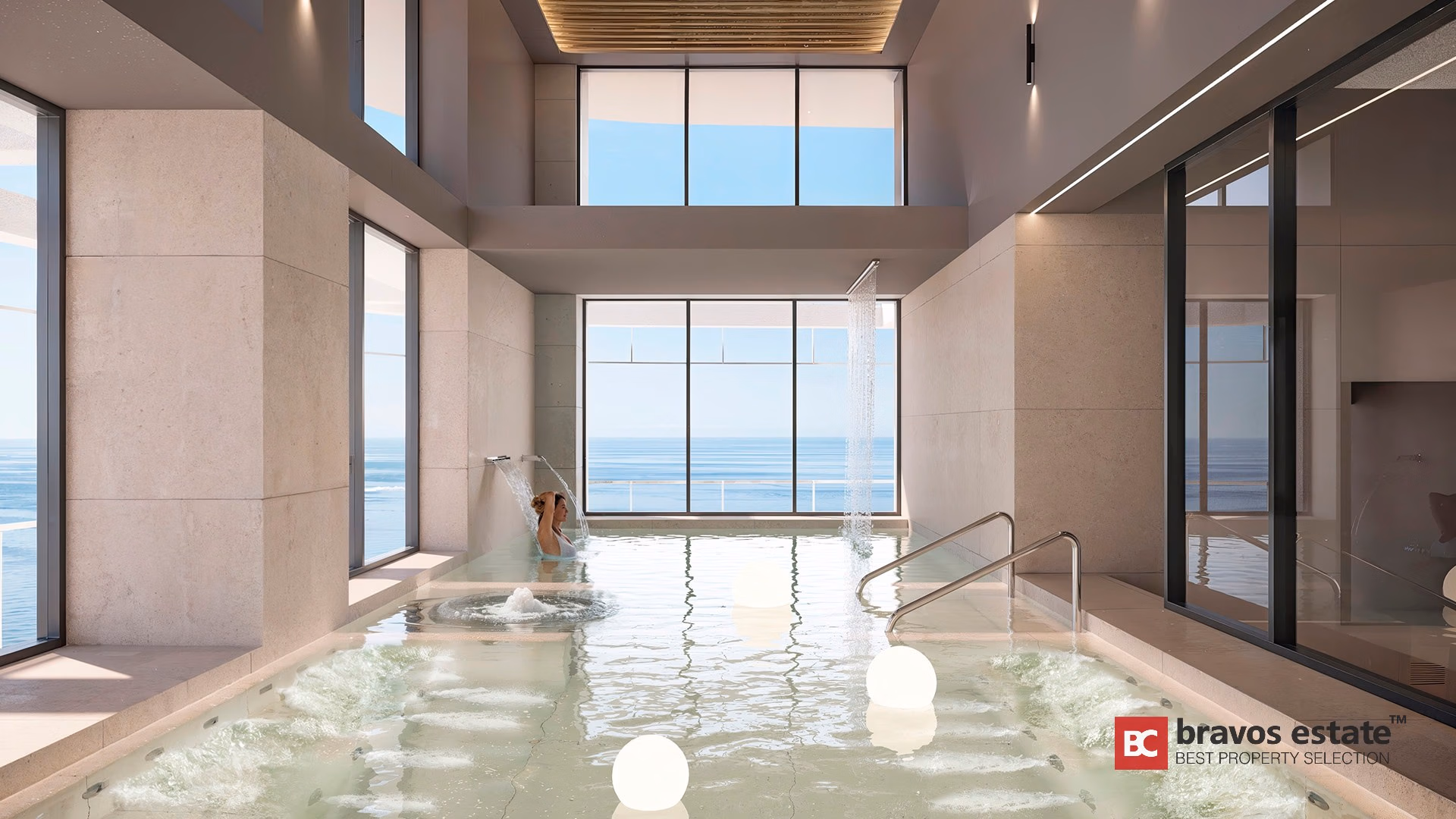 Piscina interior de hidroterapia con chorros de agua, revestimiento de travertino y vistas al mar en TM Tower Benidorm