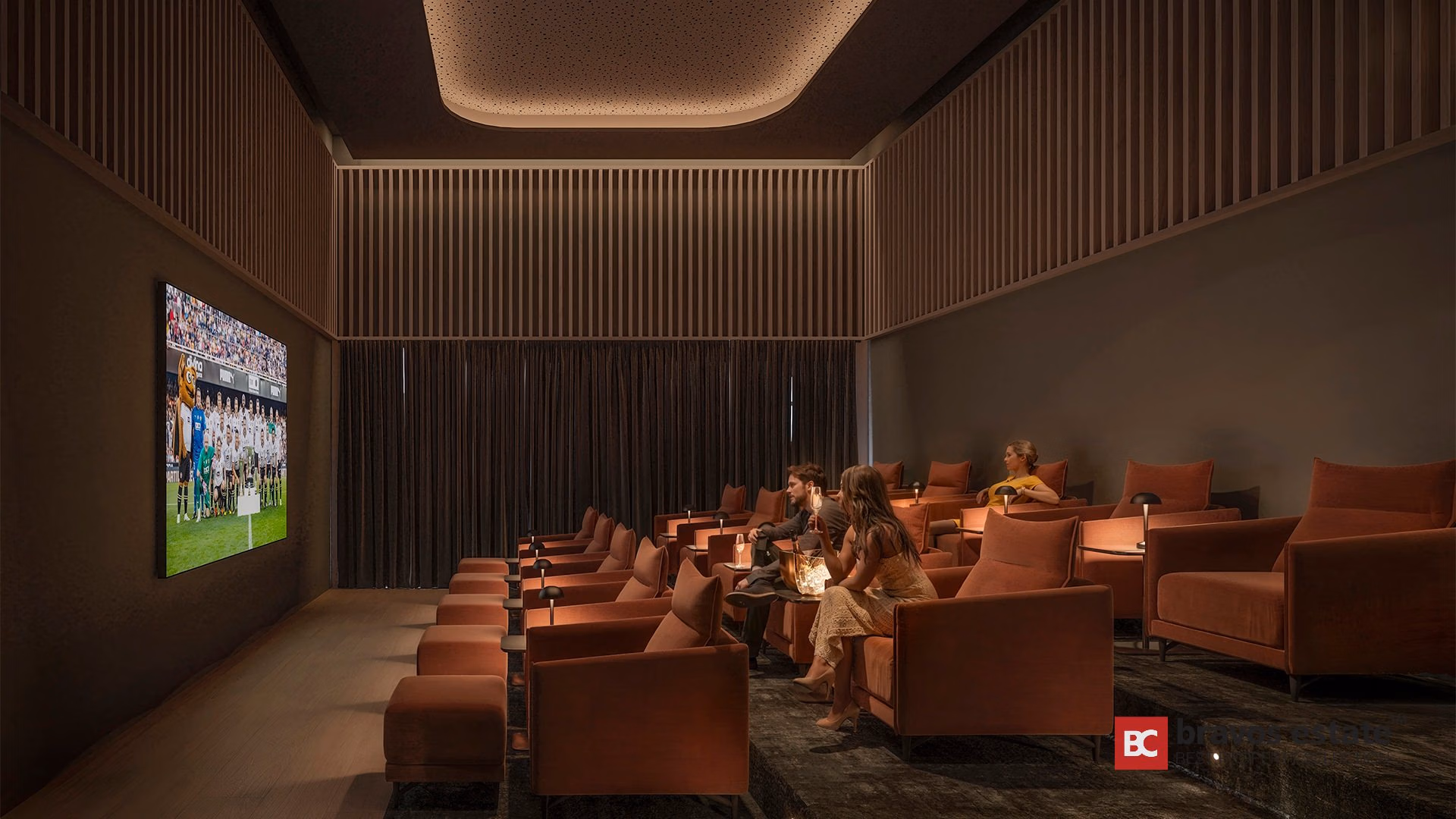 Sala de cine privada en TM Tower con butacas de terciopelo terracota, paneles de listones verticales y pantalla grande