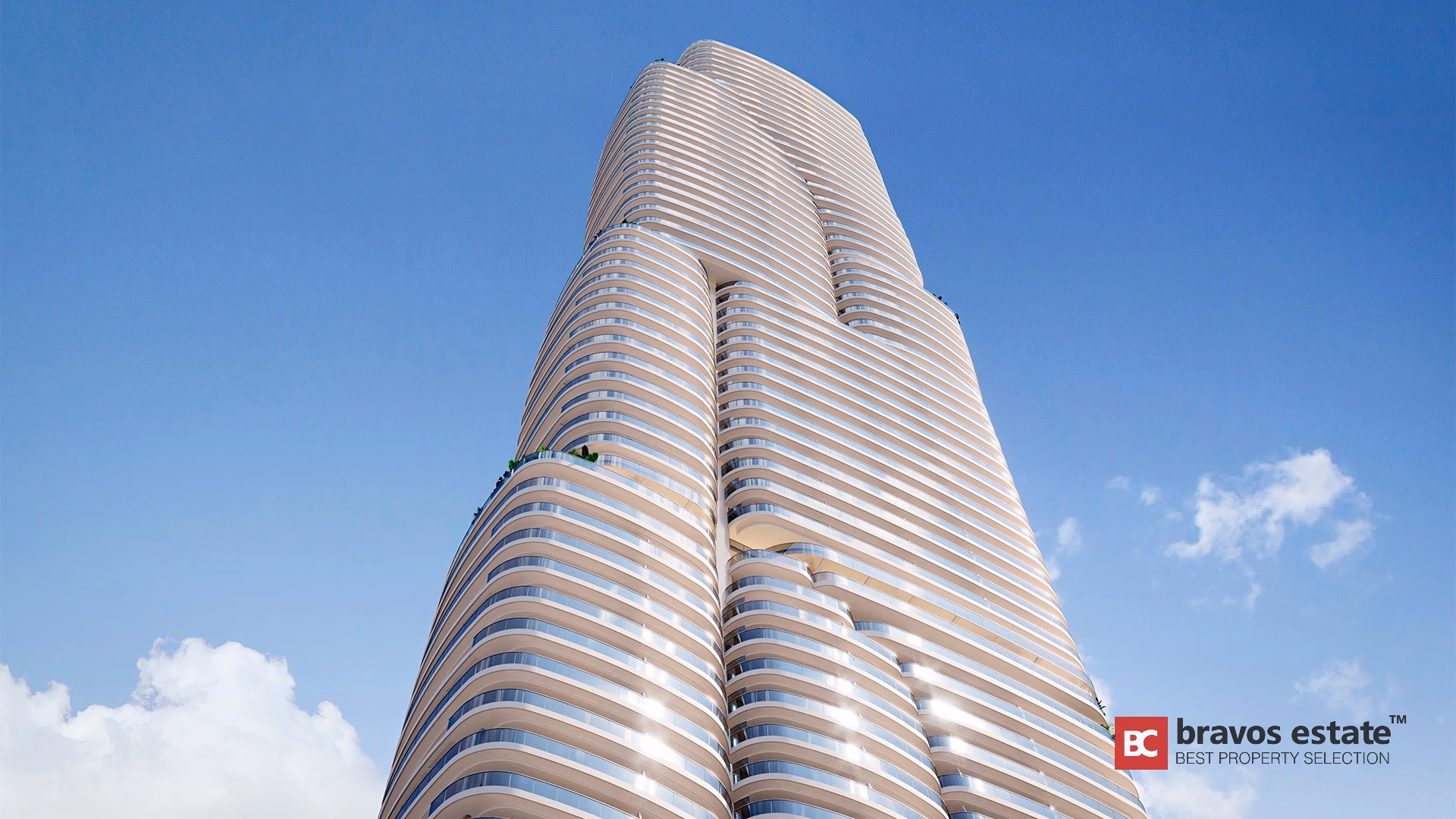 Torre TM Tower en Playa de Poniente con fachada ondulada en tono crema y balcones perimetrales vista desde abajo