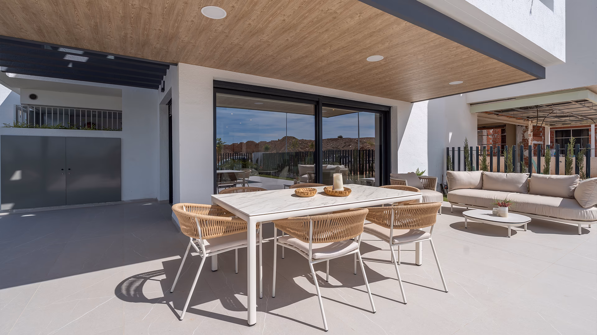 Comedor en terraza bajo pérgola